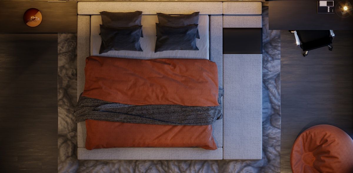 A staged home interior with the kitchen packed in boxes, a living room full of wrapped framed art and coiled cords, a bedroom mattress in a protective bag, and bathroom items sorted into bins